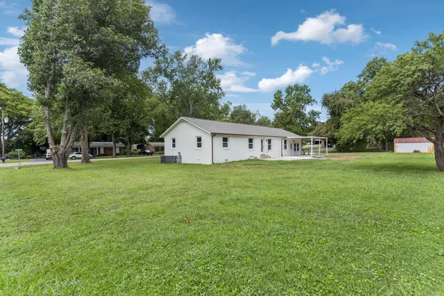 a view of house with garden and trees