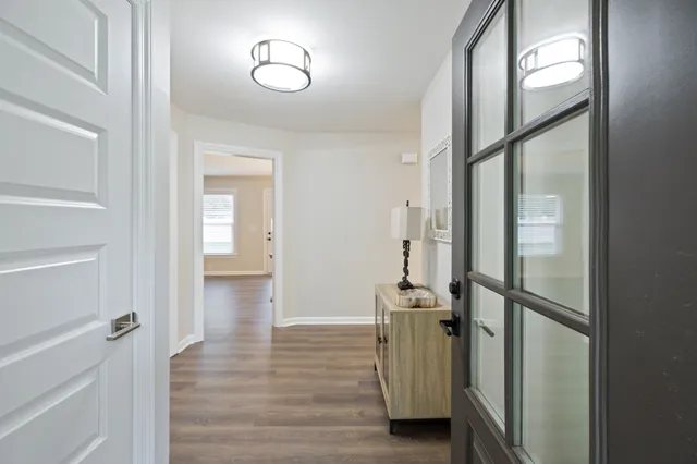 a view of a hallway with wooden floor and glass door