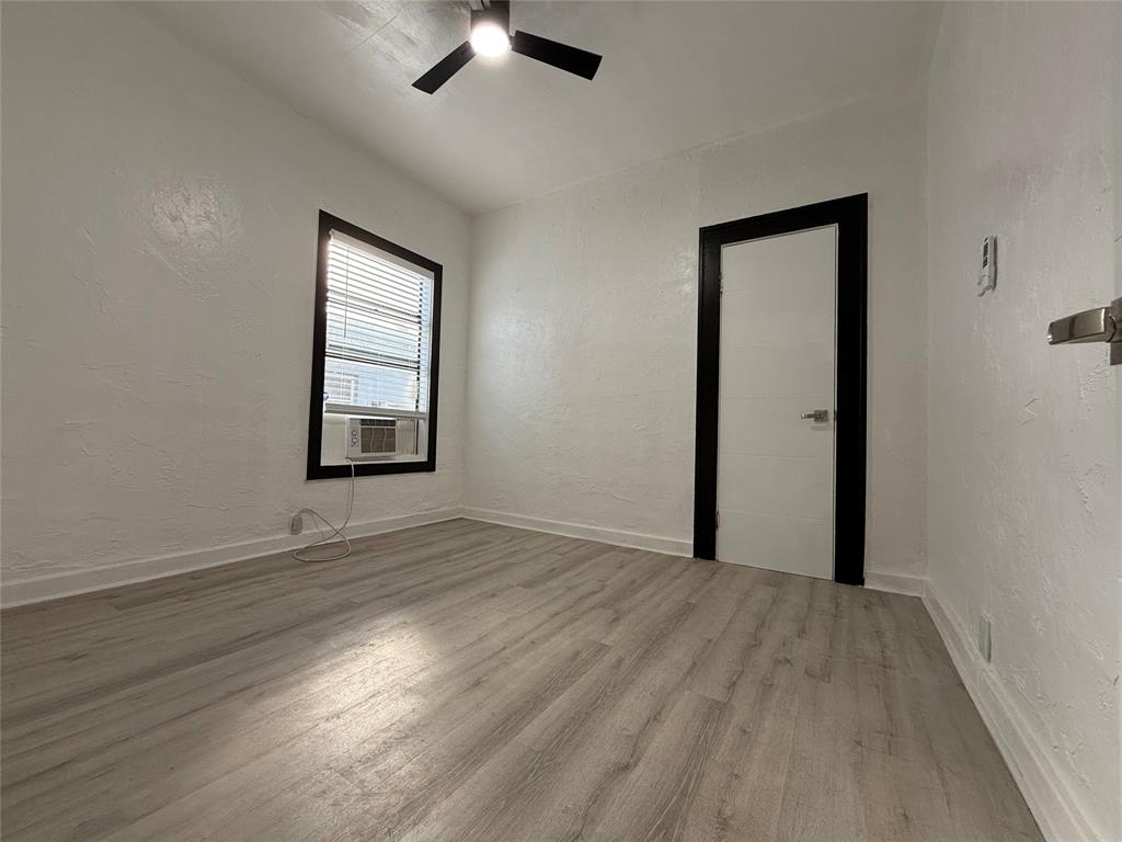 1947 Madison Street, Unit 4 Hollywood, FL 33020 - Photo 9 of 15 an empty room with wooden floor cabinet and windows