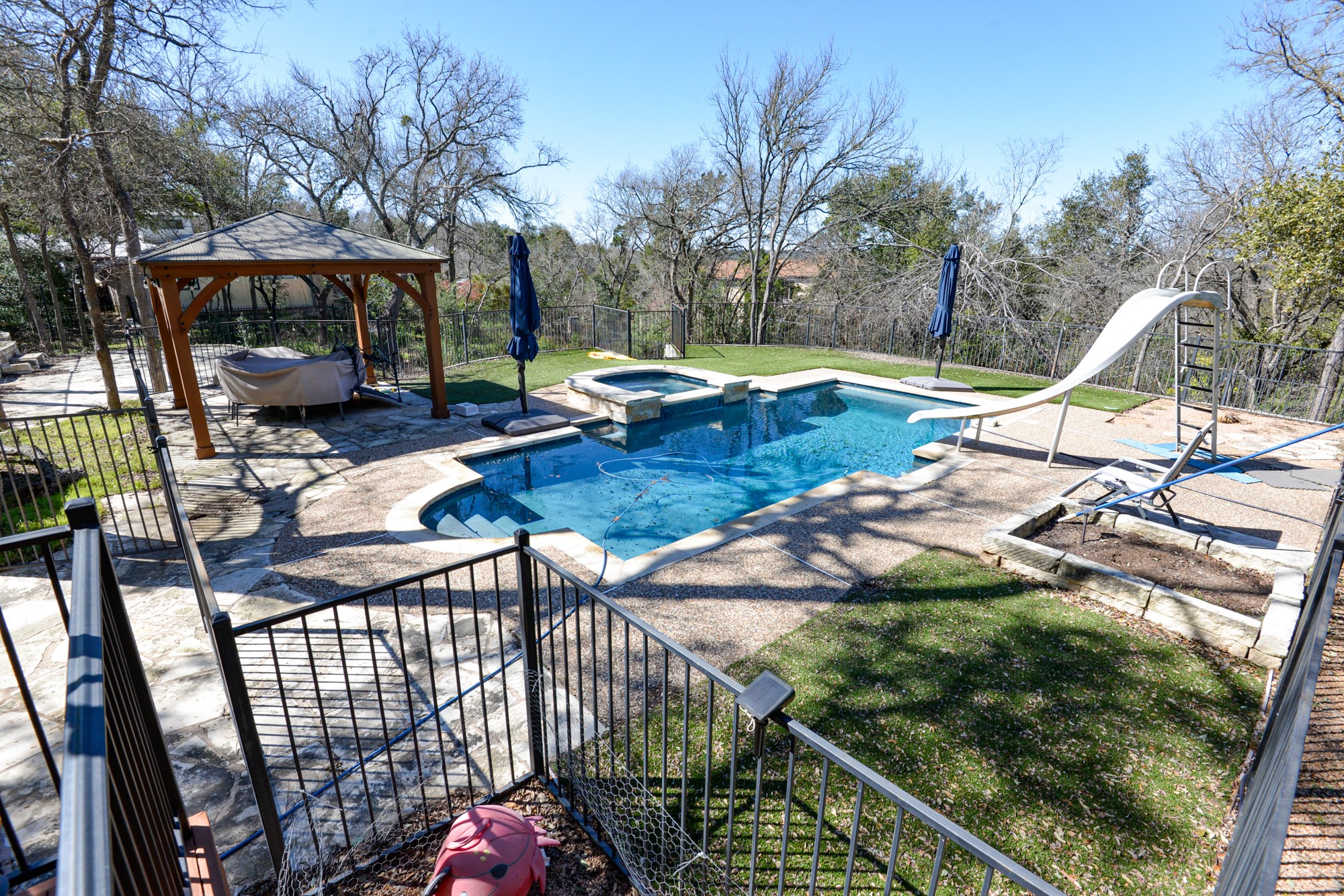 10710 D-K Ranch Road Austin, TX 78759 - Photo 28 of 34 An inviting backyard oasis offers a sparkling pool with slide and a charming gazebo, perfect for relaxation.