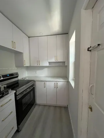 a kitchen with cabinets appliances and a window