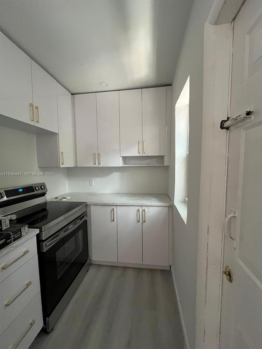 610 Southwest 13th Avenue, Unit 4 Miami, FL 33135 - Photo 2 of 10 a kitchen with cabinets appliances and a window