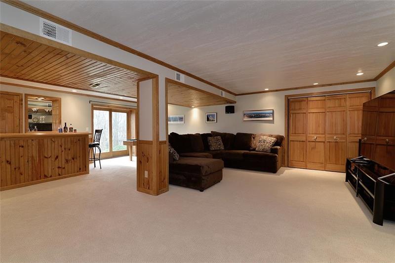 12 Lockwood Road Baden, PA 15005 - Photo 22 of 25 Lower Level has LARGE Game room w/ Wet Bar, Refrigerator, wine cooler fridge and STORAGE GALORE! Door opens to lower level patio and the AMAZING backyard with Treehouse & Swing Set.