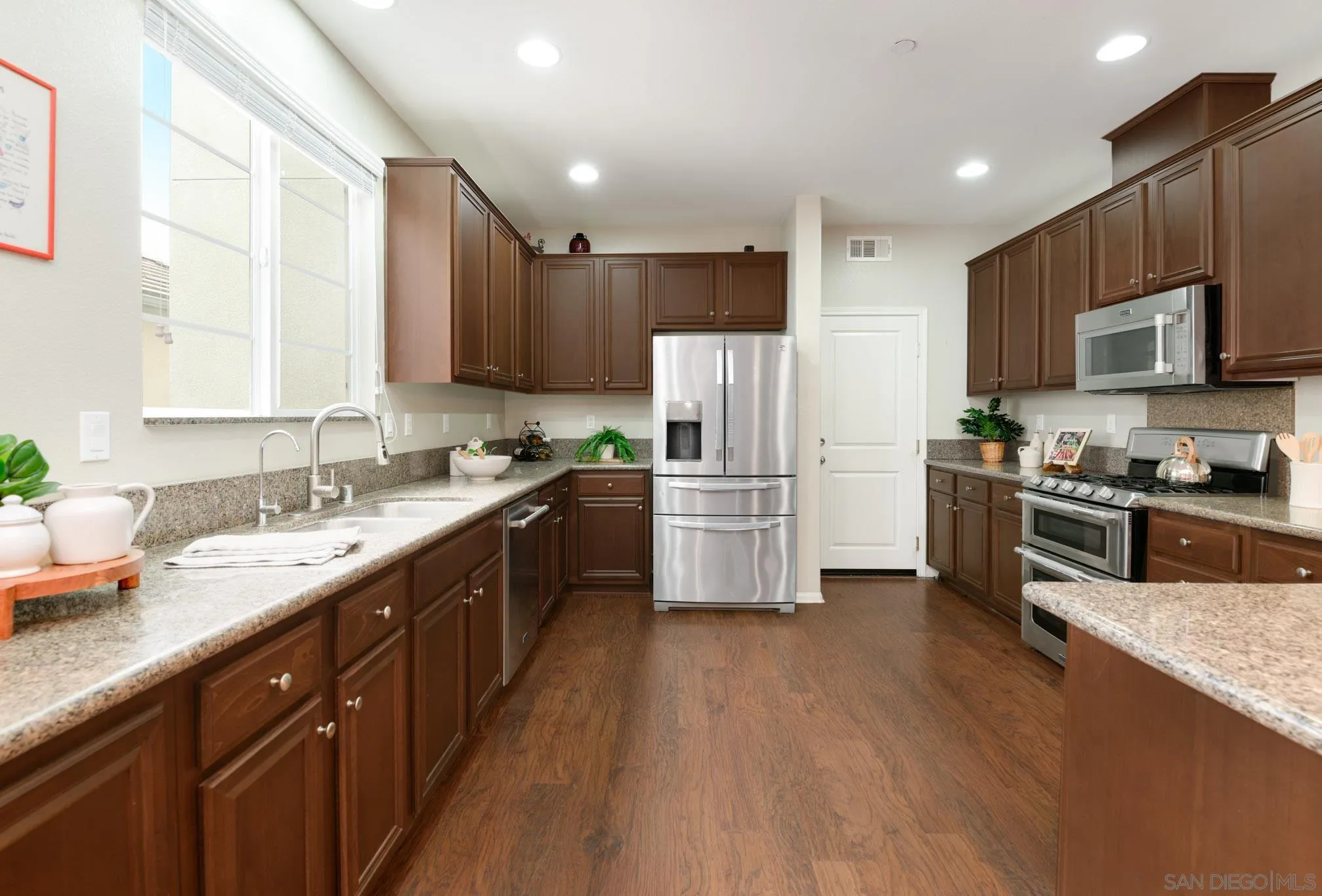 1767 Ragtime Way Oceanside, CA 92054 - Photo 8 of 28 a kitchen with stainless steel appliances a refrigerator sink cabinets and wooden floor