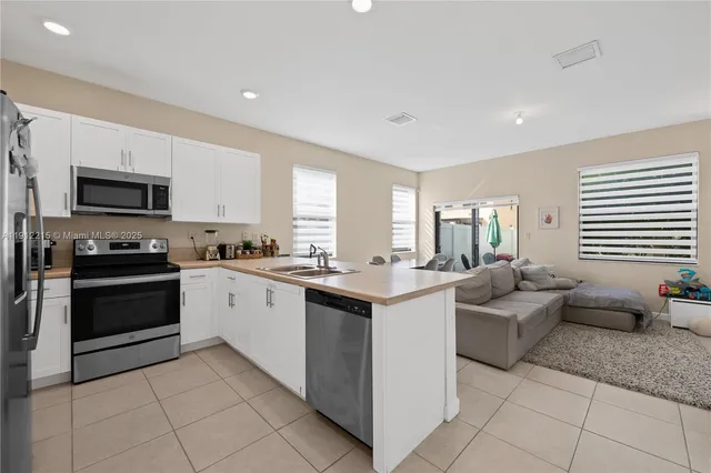 a kitchen with stainless steel appliances kitchen island granite countertop a sink and cabinets