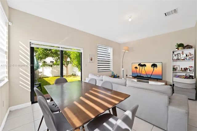 a living room with furniture a floor to ceiling window and a flat screen tv