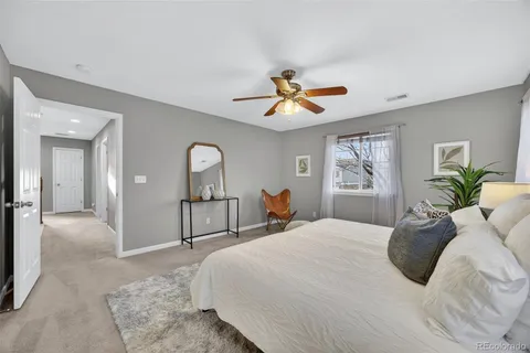 a bedroom with a bed ceiling fan and a window