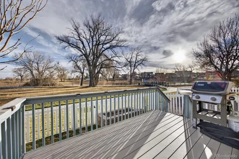 a view of a deck with trees in front of it