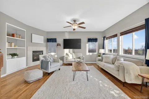 a living room with furniture fireplace and a large window