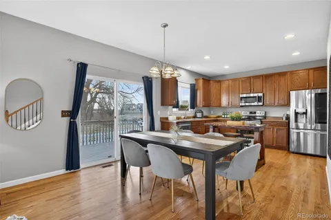 a kitchen with stainless steel appliances granite countertop a stove a refrigerator a kitchen island a table and chairs