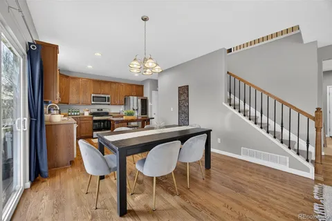 a view of a dining room with furniture wooden floor and chandelier