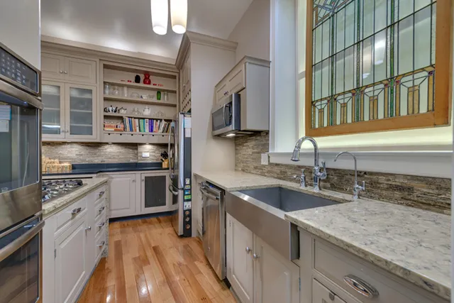 a kitchen with stainless steel appliances granite countertop a sink and a stove