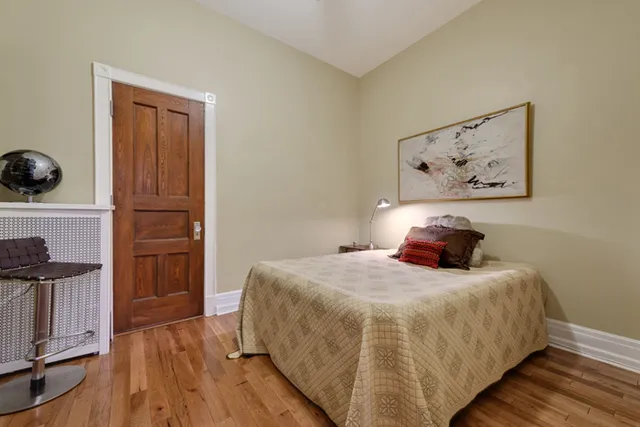 a bedroom with a bed and wooden floor