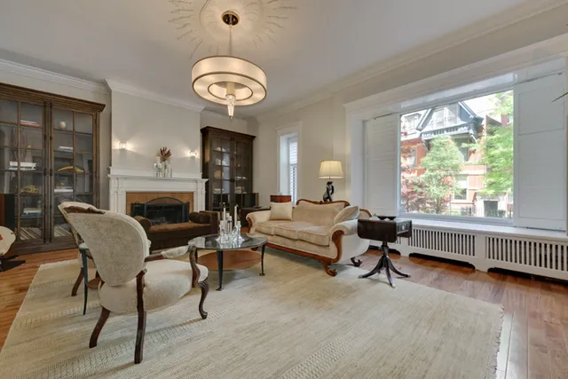 a living room with furniture a fireplace and a large window