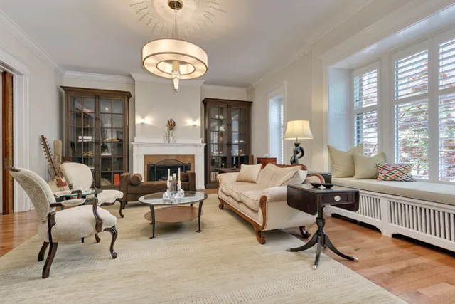a living room with furniture a fireplace and a large window