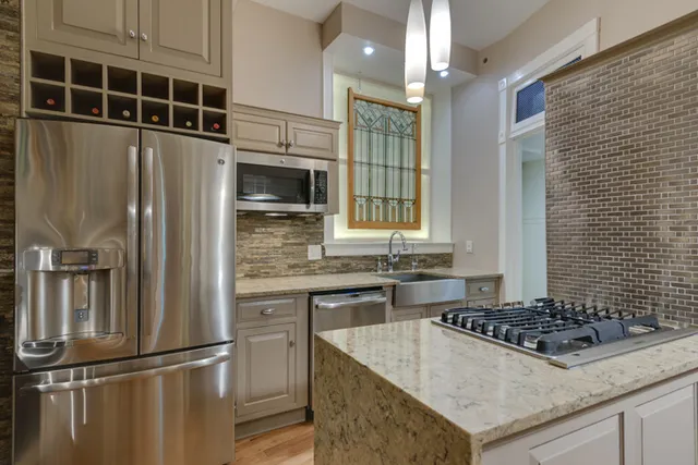 a kitchen with granite countertop a sink stove and refrigerator