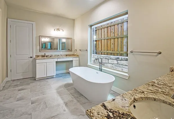 a spacious bathroom with a double vanity sink mirror and bathtub