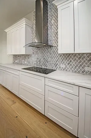 a kitchen with granite countertop white cabinets and sink