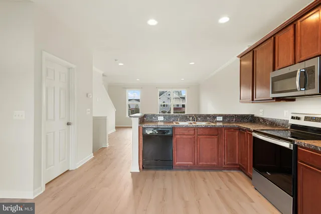 a kitchen with stainless steel appliances granite countertop a stove sink and cabinets