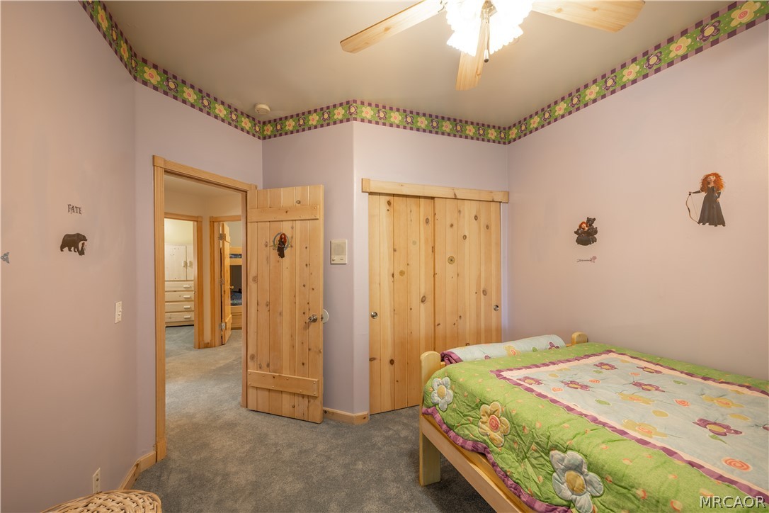 277 Grizzly Road Lake Arrowhead, CA 92352 - Photo 21 of 33 a bedroom with a bed and a chandelier