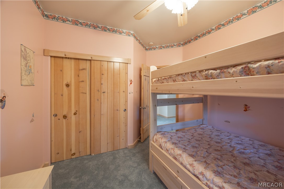 277 Grizzly Road Lake Arrowhead, CA 92352 - Photo 23 of 33 a spacious bedroom with a large bed and a chandelier