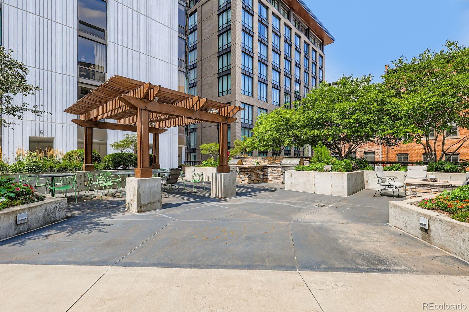 1625 Larimer Street, Unit 1007 Denver, CO 80202 - Photo 18 of 28 a patio with a table and chairs under an umbrella