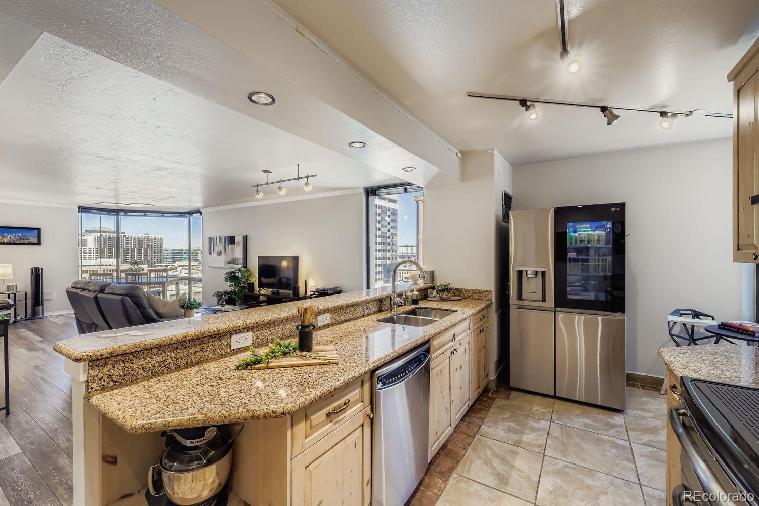 1625 Larimer Street, Unit 1007 Denver, CO 80202 - Photo 2 of 28 a kitchen with stainless steel appliances granite countertop a sink and a refrigerator