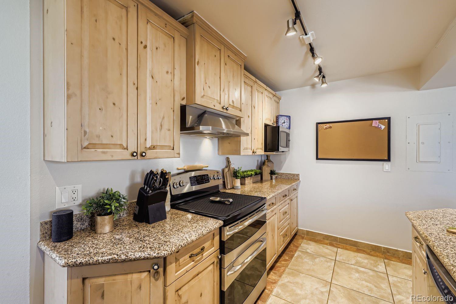 1625 Larimer Street, Unit 1007 Denver, CO 80202 - Photo 6 of 28 a kitchen with granite countertop a sink a stove and cabinets