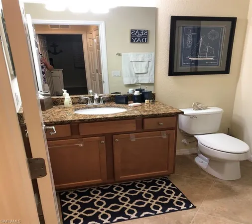 a bathroom with a toilet a sink and mirror