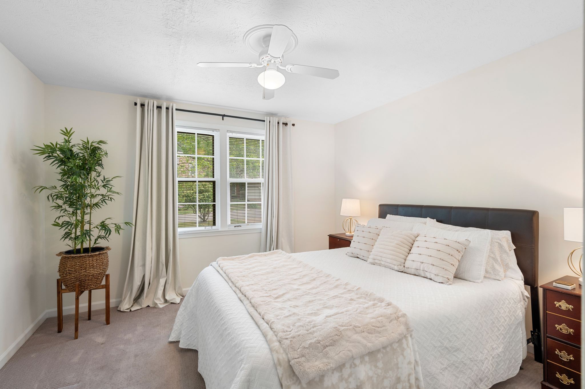 215 Devrow Court Franklin, TN 37064 - Photo 24 of 46 a bedroom with a large bed and a potted plant