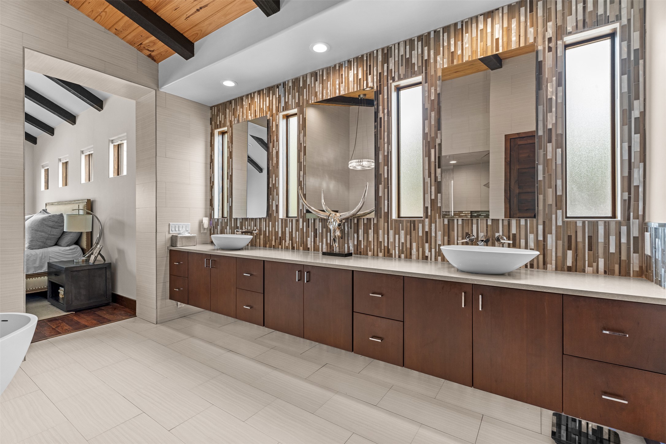 421 Rolling Hills Road Blanco, TX 78606 - Photo 14 of 40 The bathroom features a long floating vanity with a light-colored countertop and two vessel sinks.