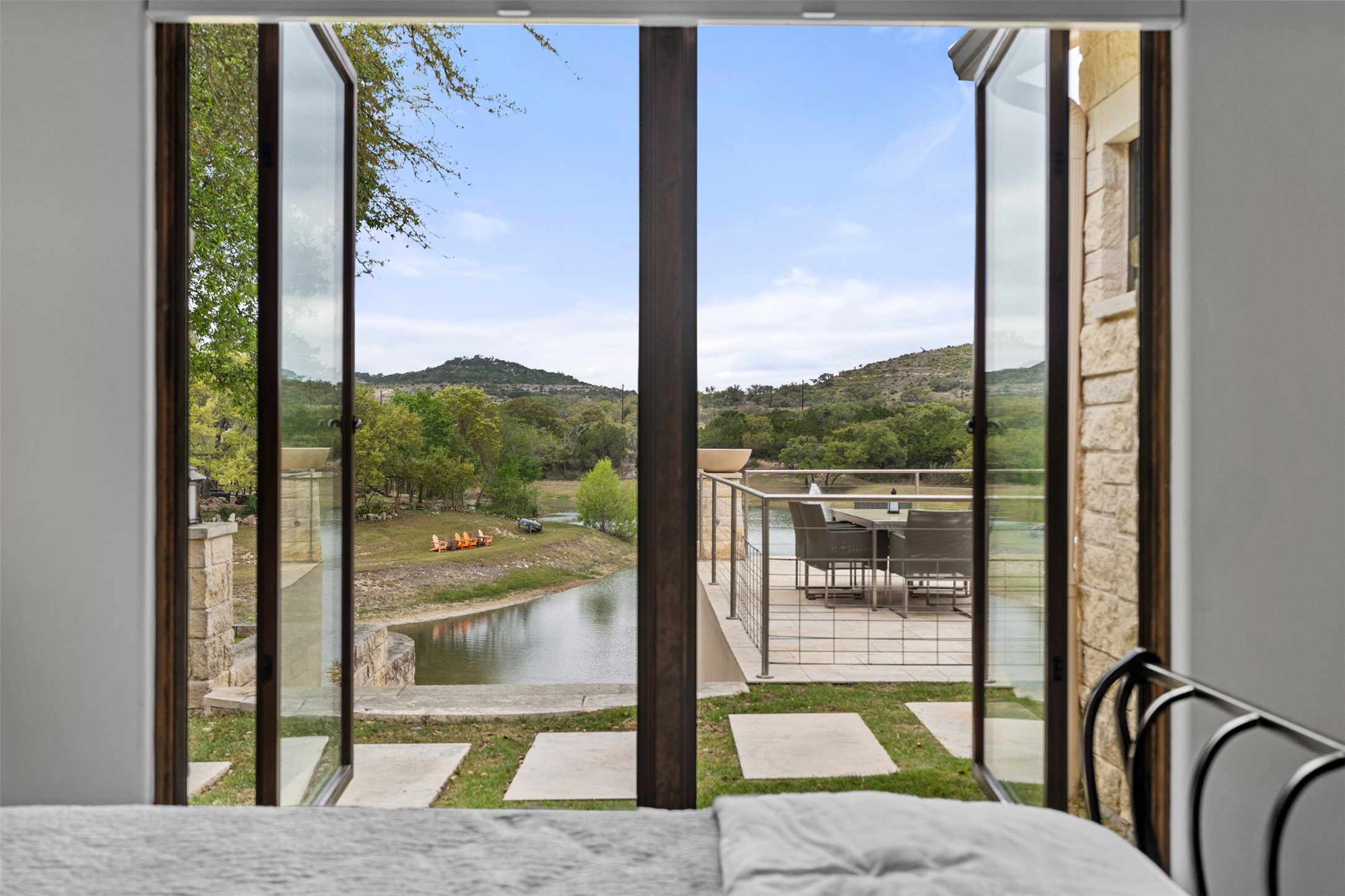 421 Rolling Hills Road Blanco, TX 78606 - Photo 17 of 40 Expansive glass windows open beautiful lake and hill country views.