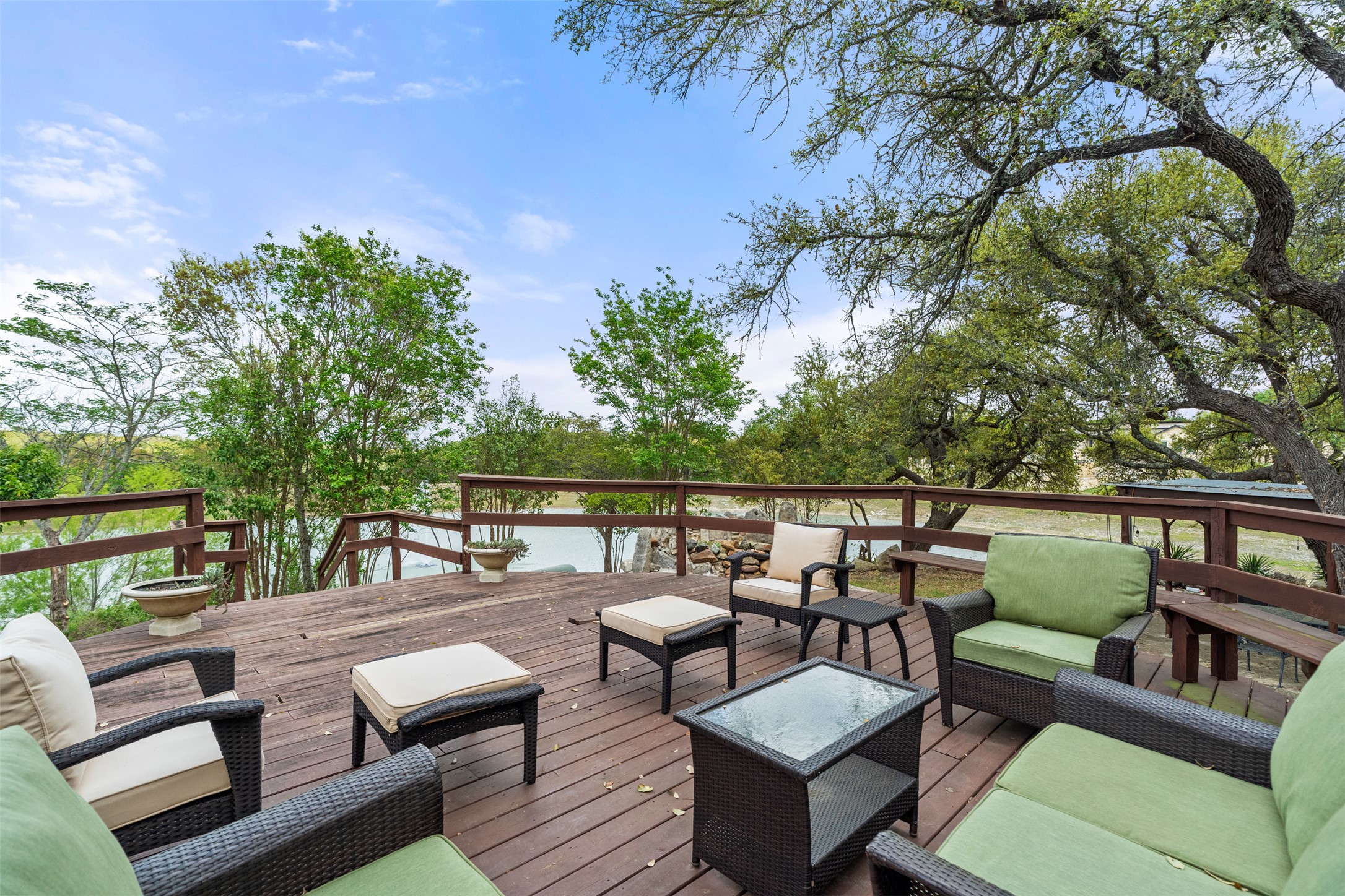 421 Rolling Hills Road Blanco, TX 78606 - Photo 28 of 40 Expansive wood deck with a serene view of the water and surrounding trees.