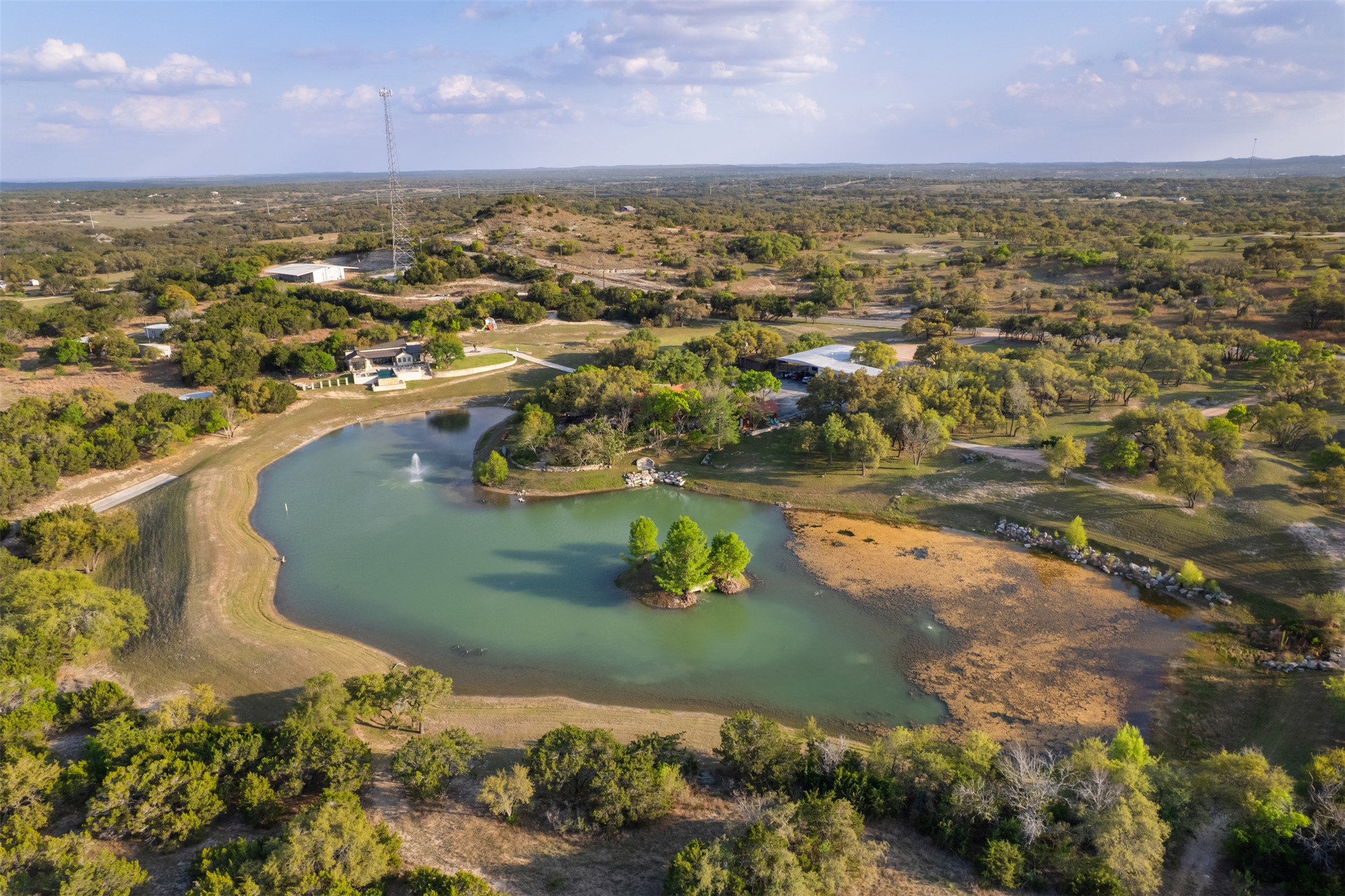 421 Rolling Hills Road Blanco, TX 78606 - Photo 39 of 40 Expansive outdoor property with a private lake featuring an island and a fountain.