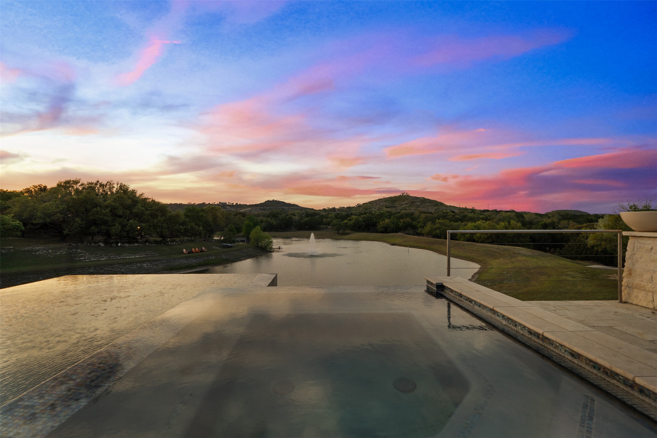 421 Rolling Hills Road Blanco, TX 78606 - Photo 6 of 40 Gorgeous infinity pool and hot tub overlooking the 3 acre lake and beautiful Hill Country sunsets.