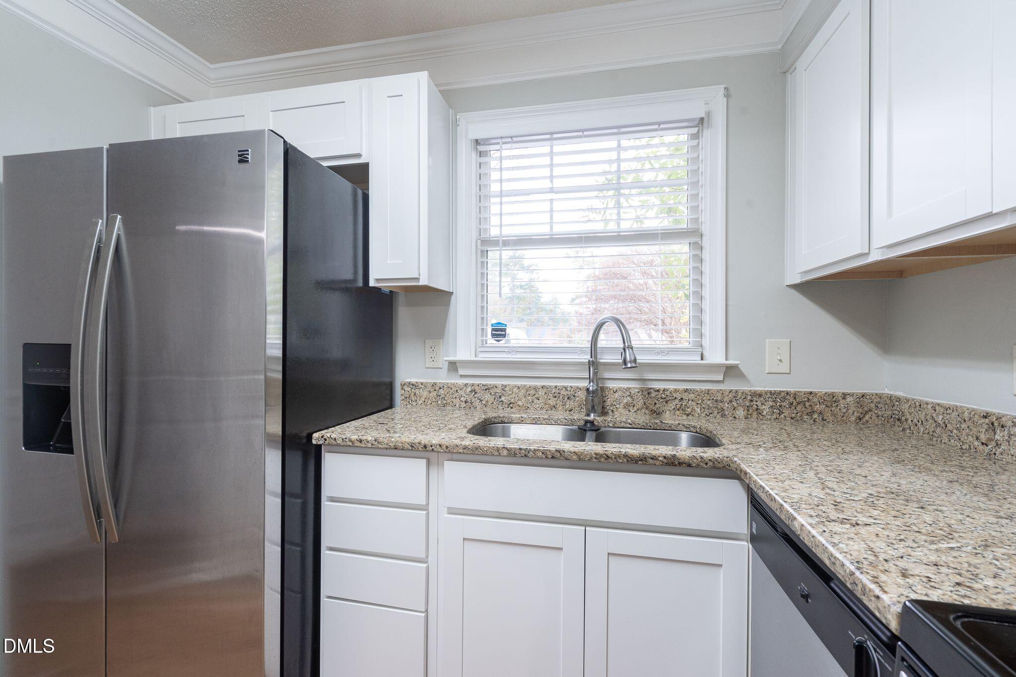 4418 Roller Court Raleigh, NC 27604 - Photo 3 of 13 a kitchen with stainless steel appliances granite countertop a refrigerator and a sink