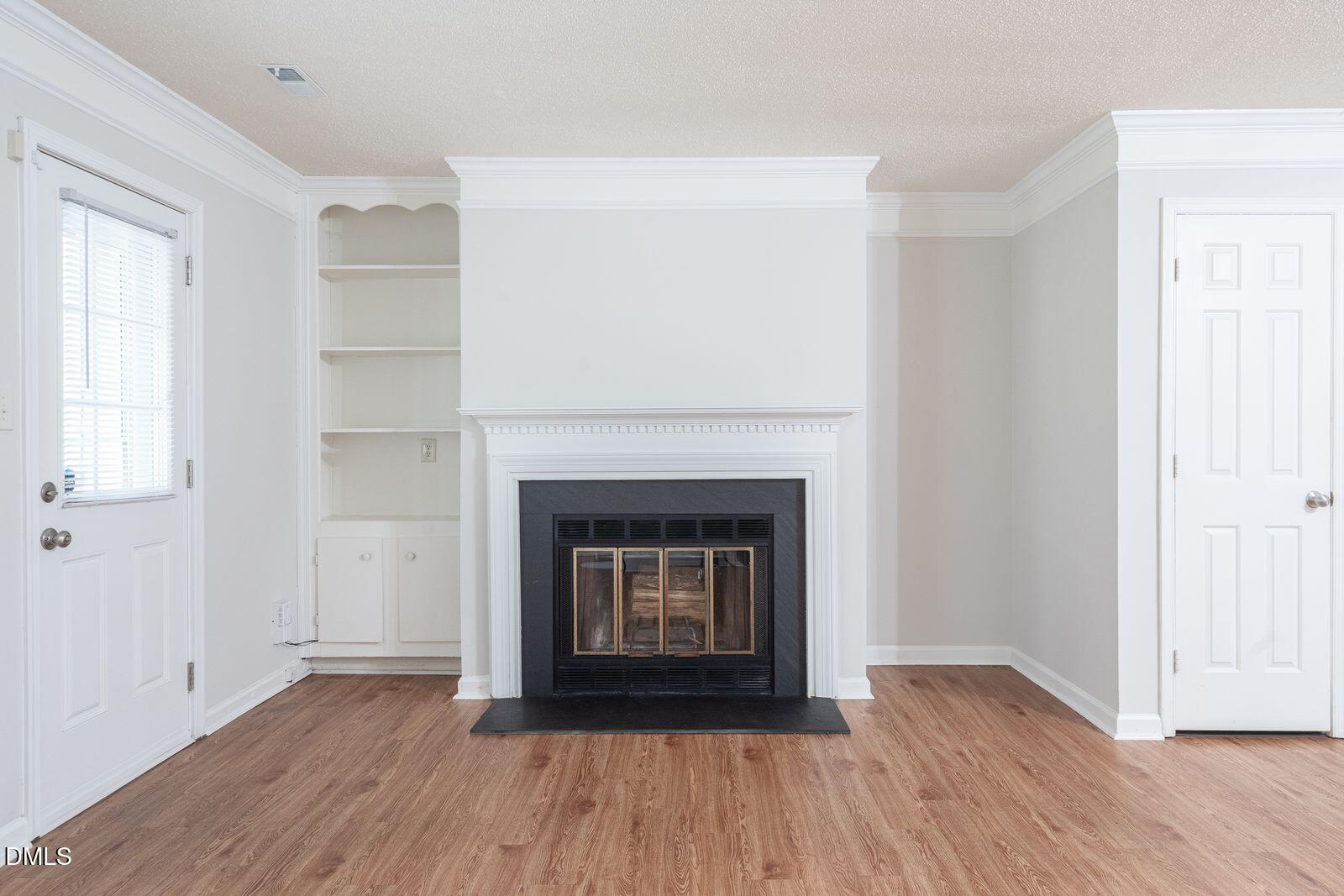 4418 Roller Court Raleigh, NC 27604 - Photo 4 of 13 a living room with a fireplace and wooden floor