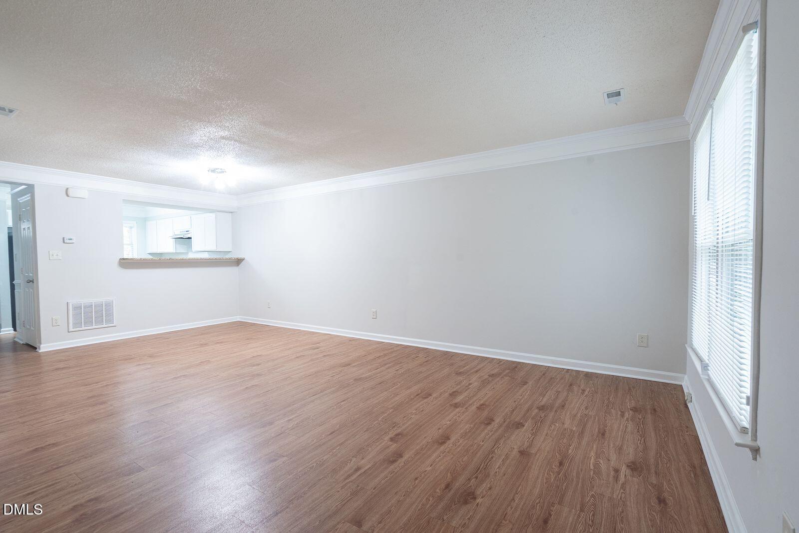 4418 Roller Court Raleigh, NC 27604 - Photo 5 of 13 an empty room with wooden floor and windows