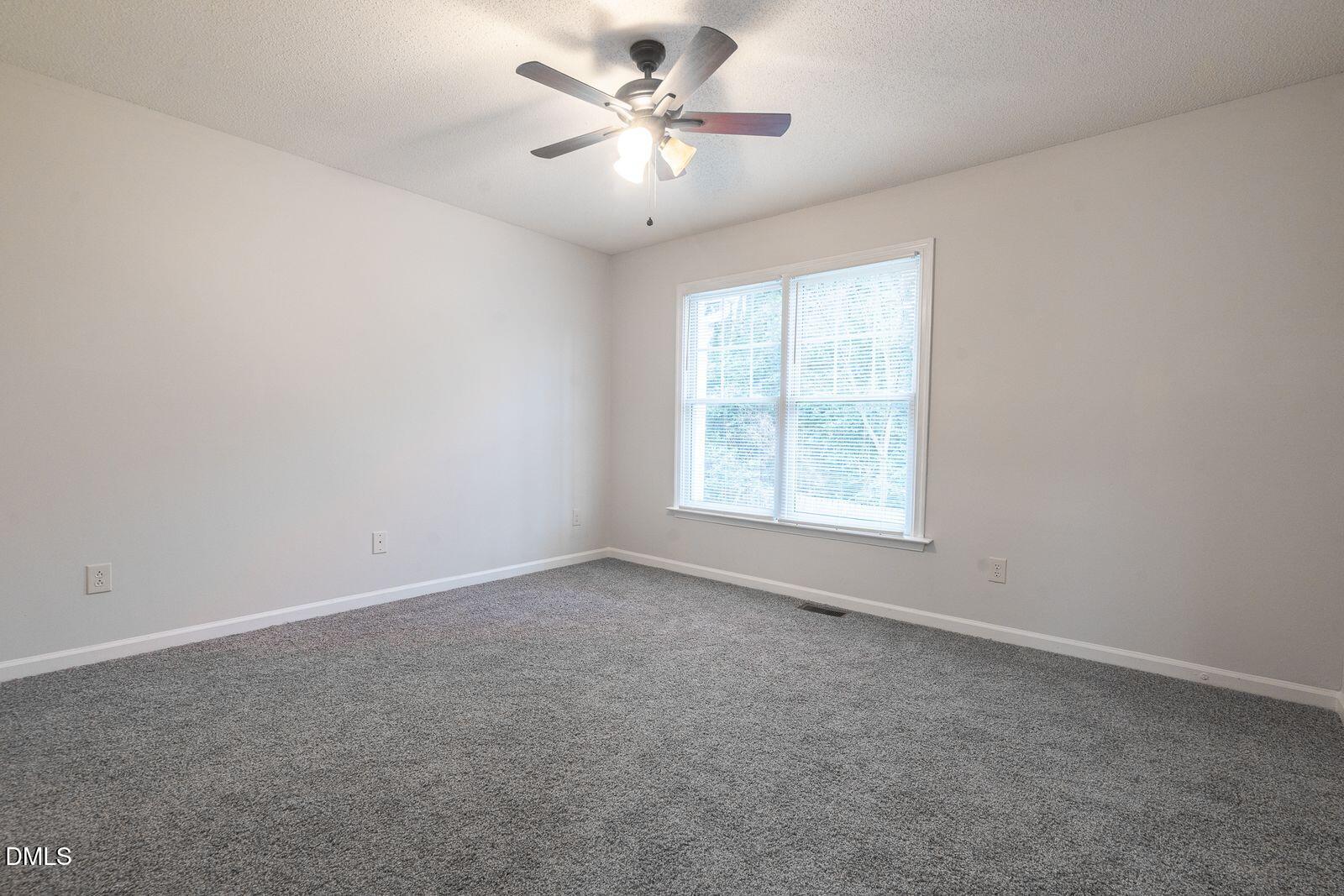 4418 Roller Court Raleigh, NC 27604 - Photo 8 of 13 an empty room with a window and a ceiling fan