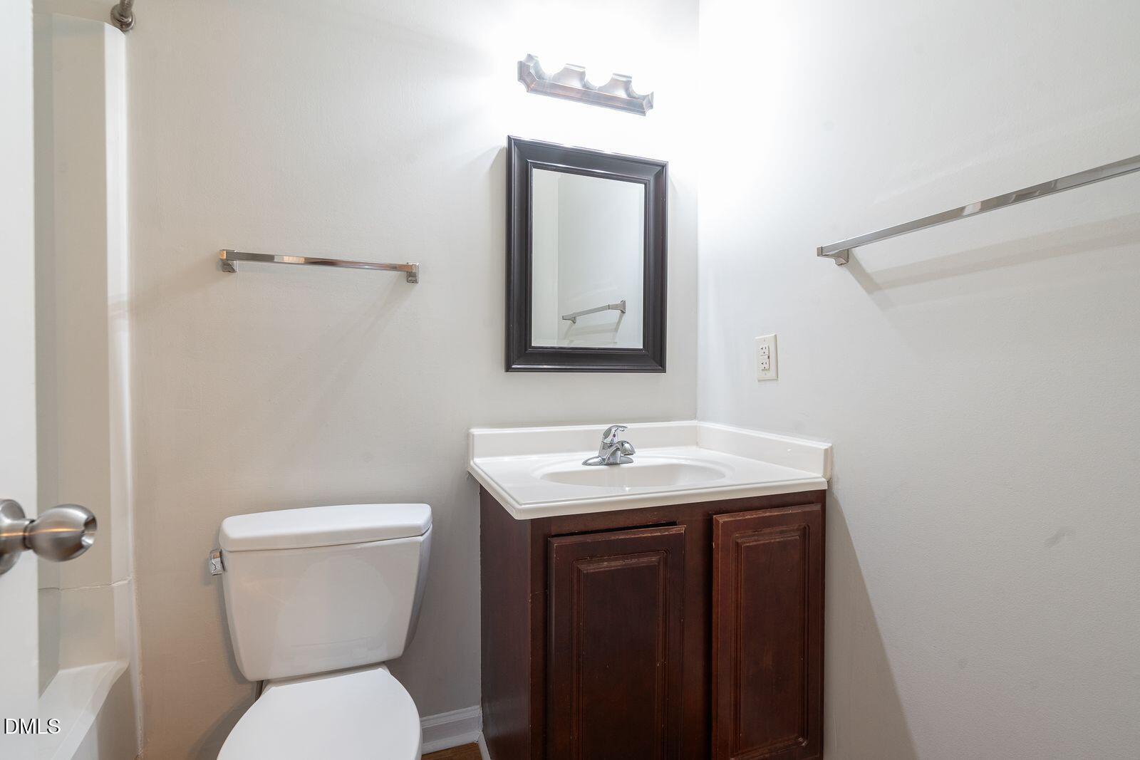 4418 Roller Court Raleigh, NC 27604 - Photo 9 of 13 a bathroom with a toilet a sink and mirror