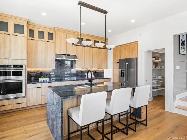 a kitchen with stainless steel appliances granite countertop a kitchen island a stove a table and chairs