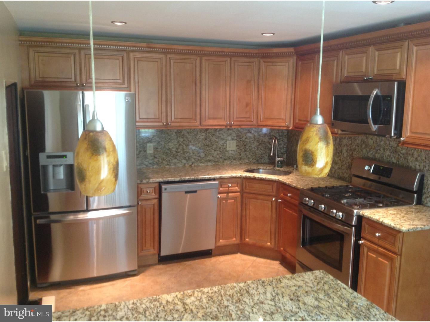 9708 Glenhope Road Philadelphia, PA 19115 - Photo 7 of 25 a kitchen with stainless steel appliances granite countertop a stove a refrigerator and a sink