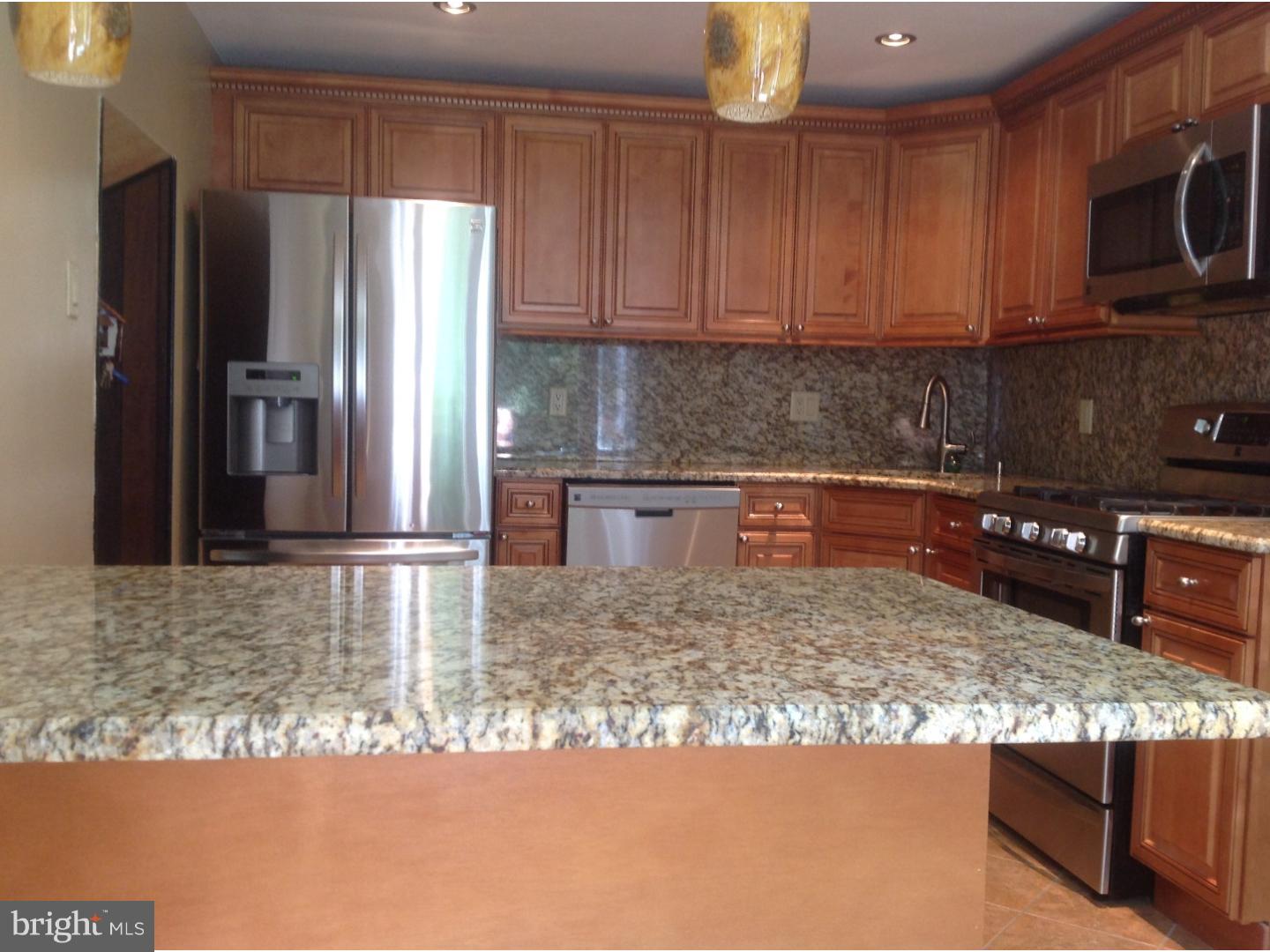 9708 Glenhope Road Philadelphia, PA 19115 - Photo 8 of 25 a kitchen with stainless steel appliances granite countertop a refrigerator and a stove top oven