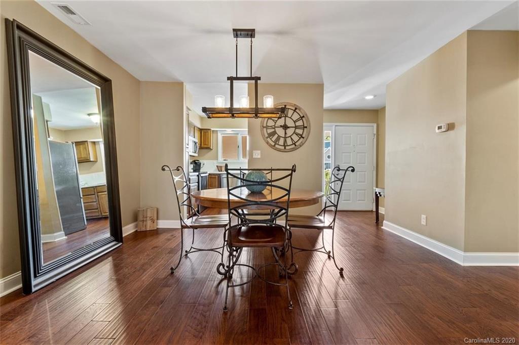 232 Queens Road, Unit 39 Charlotte, NC 28204 - Photo 14 of 29 a view of a dining room with furniture wooden floor and a chandelier