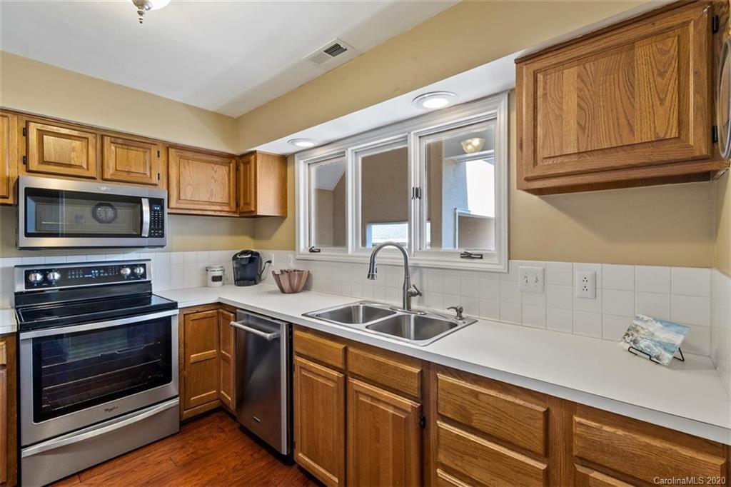 232 Queens Road, Unit 39 Charlotte, NC 28204 - Photo 7 of 29 a kitchen with stainless steel appliances granite countertop a sink stove and microwave