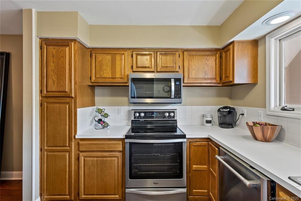 232 Queens Road, Unit 39 Charlotte, NC 28204 - Photo 8 of 29 a kitchen with stainless steel appliances granite countertop a stove and a refrigerator