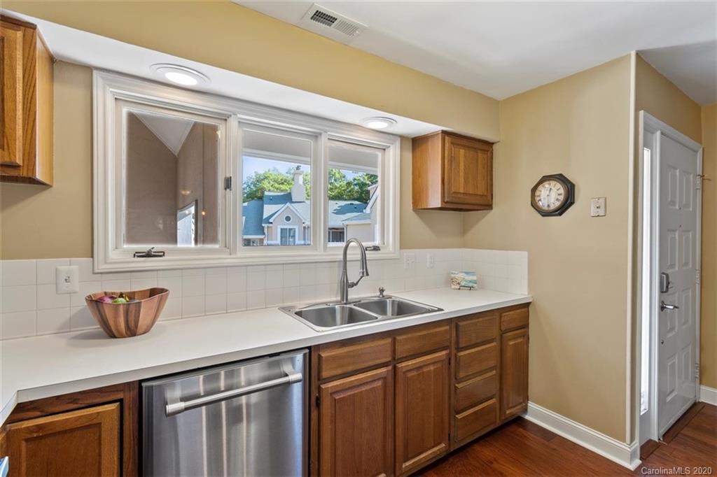 232 Queens Road, Unit 39 Charlotte, NC 28204 - Photo 9 of 29 a kitchen with stainless steel appliances granite countertop a sink and a wooden cabinets