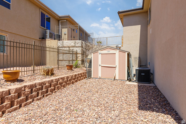 2005 West 450 S Circle St. George, UT 84770 - Photo 42 of 57 Gravel side yard featuring a storage shed, a retaining wall, and metal fencing
