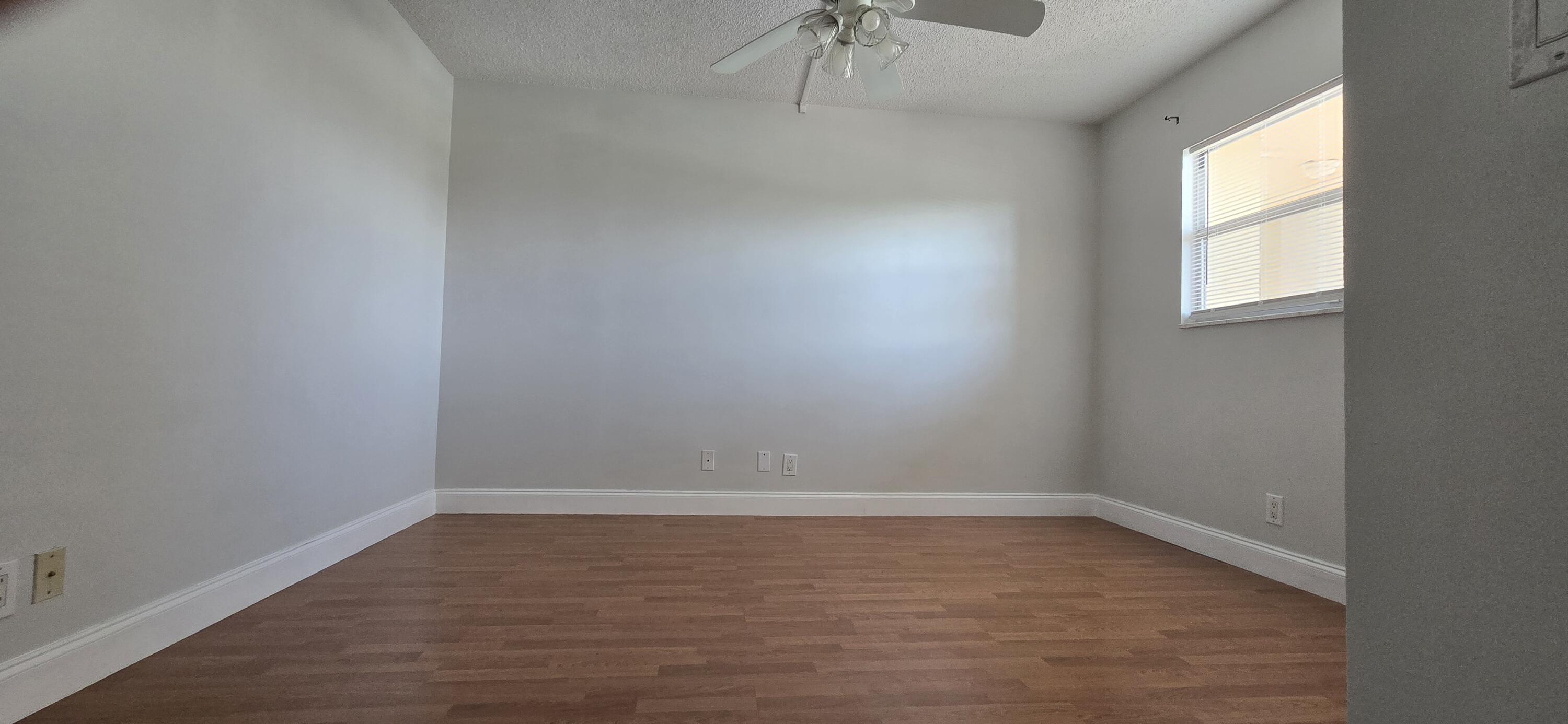 3661 Via Poinciana, Unit 306 Lake Worth, FL 33467 - Photo 3 of 13 wooden floor in an empty room with a window
