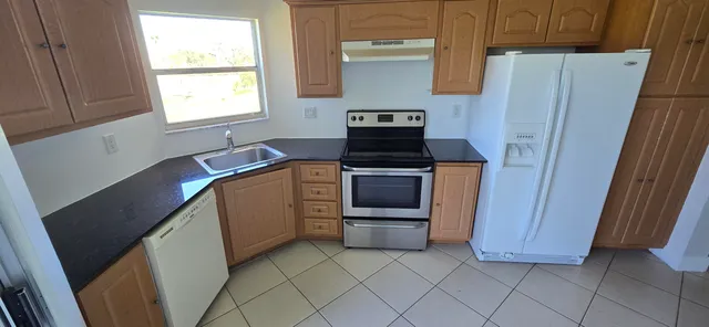 a kitchen with a stove a sink and a refrigerator